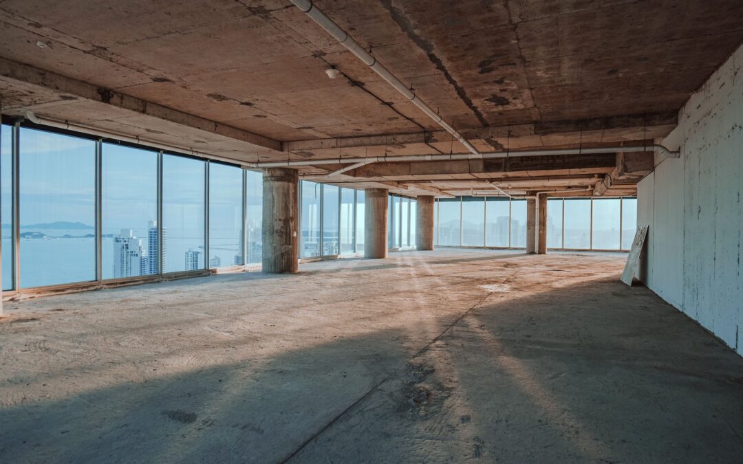 an empty office space with exposed concrete